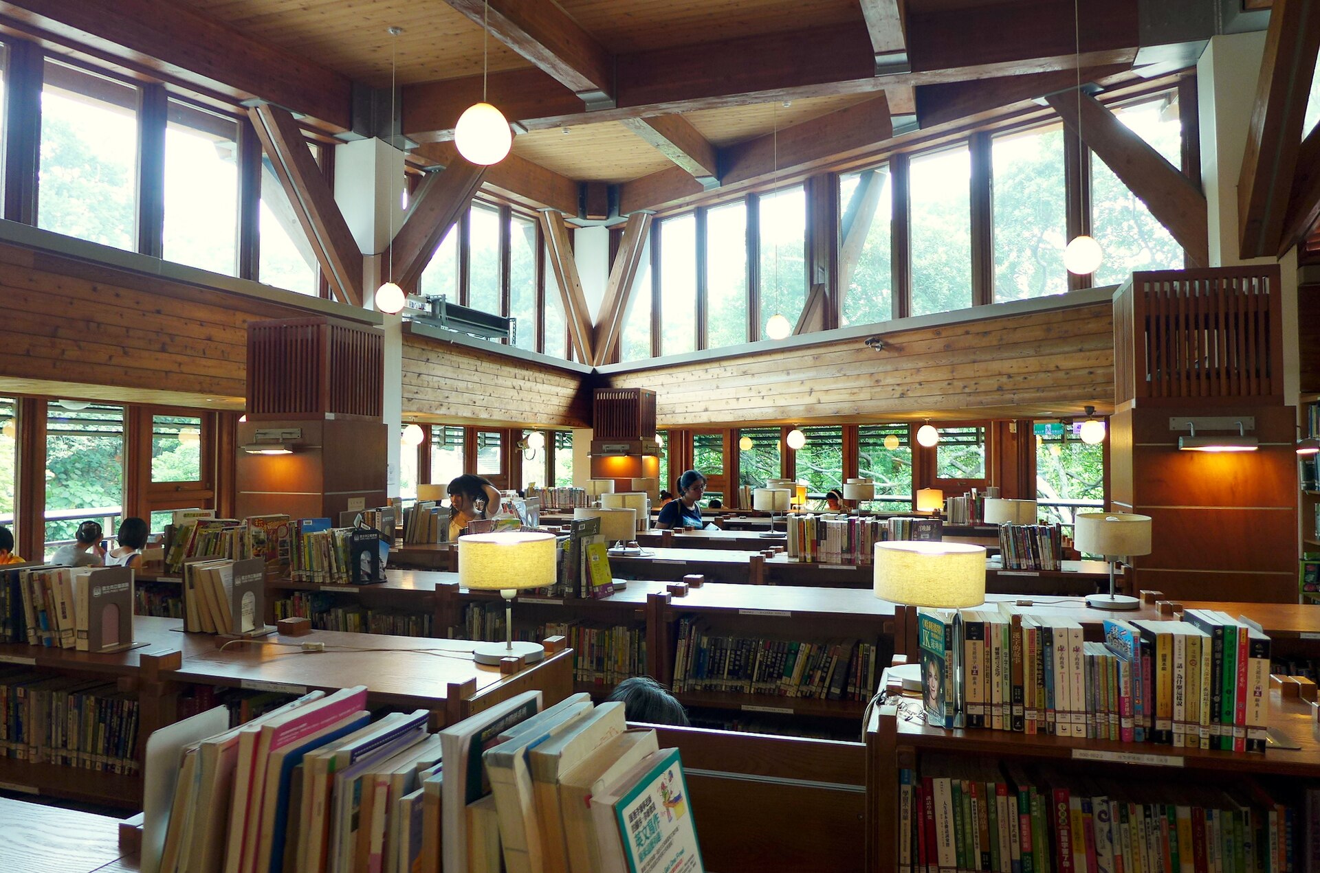 台北市立図書館北投分館の木造の吹き抜けと大きな窓、書架に囲まれた閲覧スペース