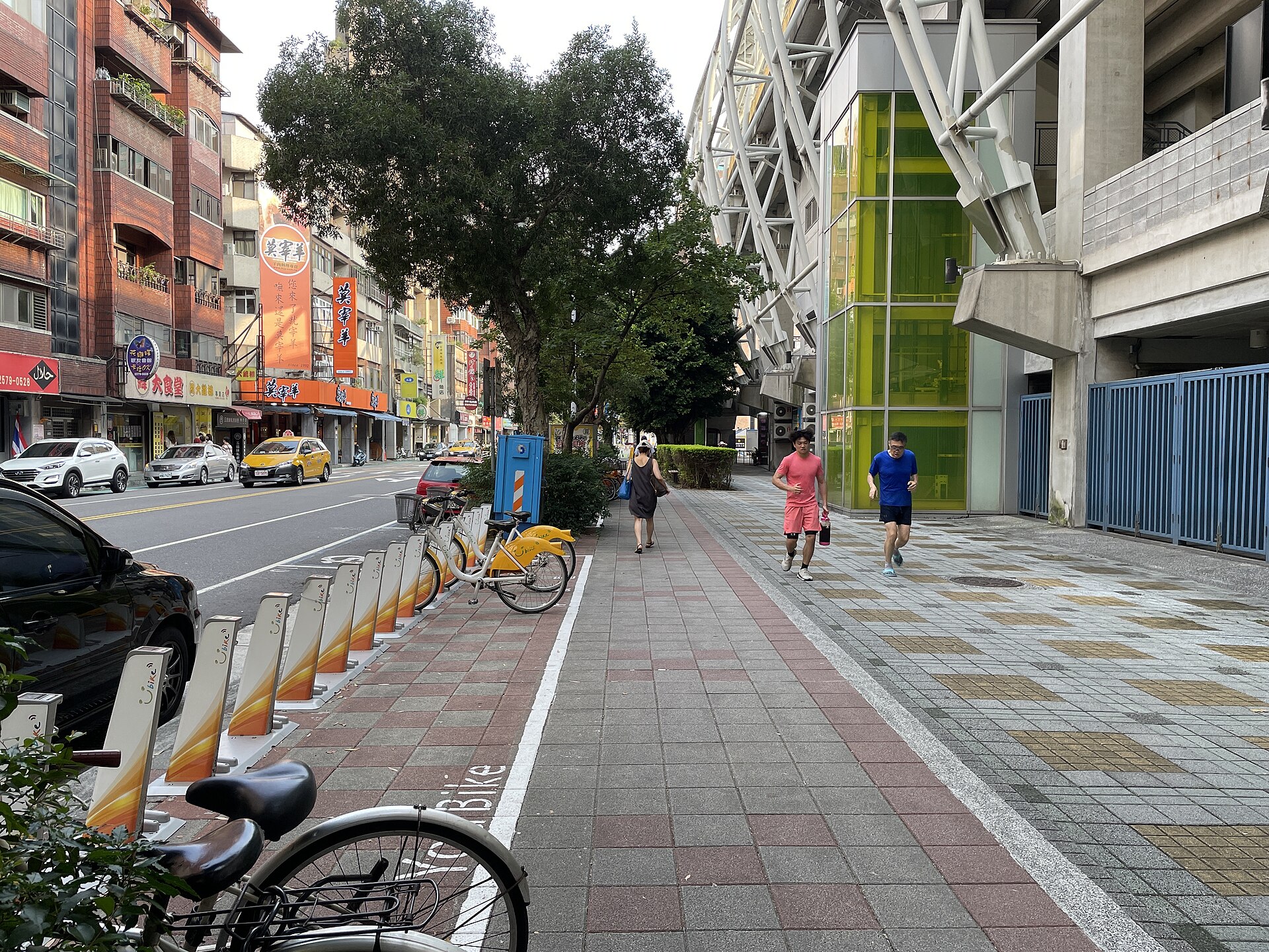 歩道に並ぶYouBikeのレンタルステーションと行き交う人々