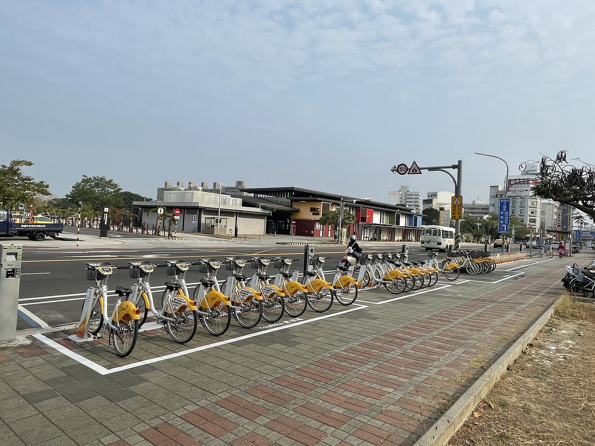 台南のYouBike 2.0レンタサイクルが並ぶ貸出ステーション、背景にバスと市街地